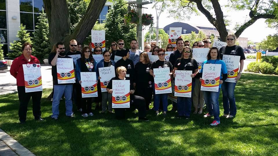 Members gathered outside with solidarity signs