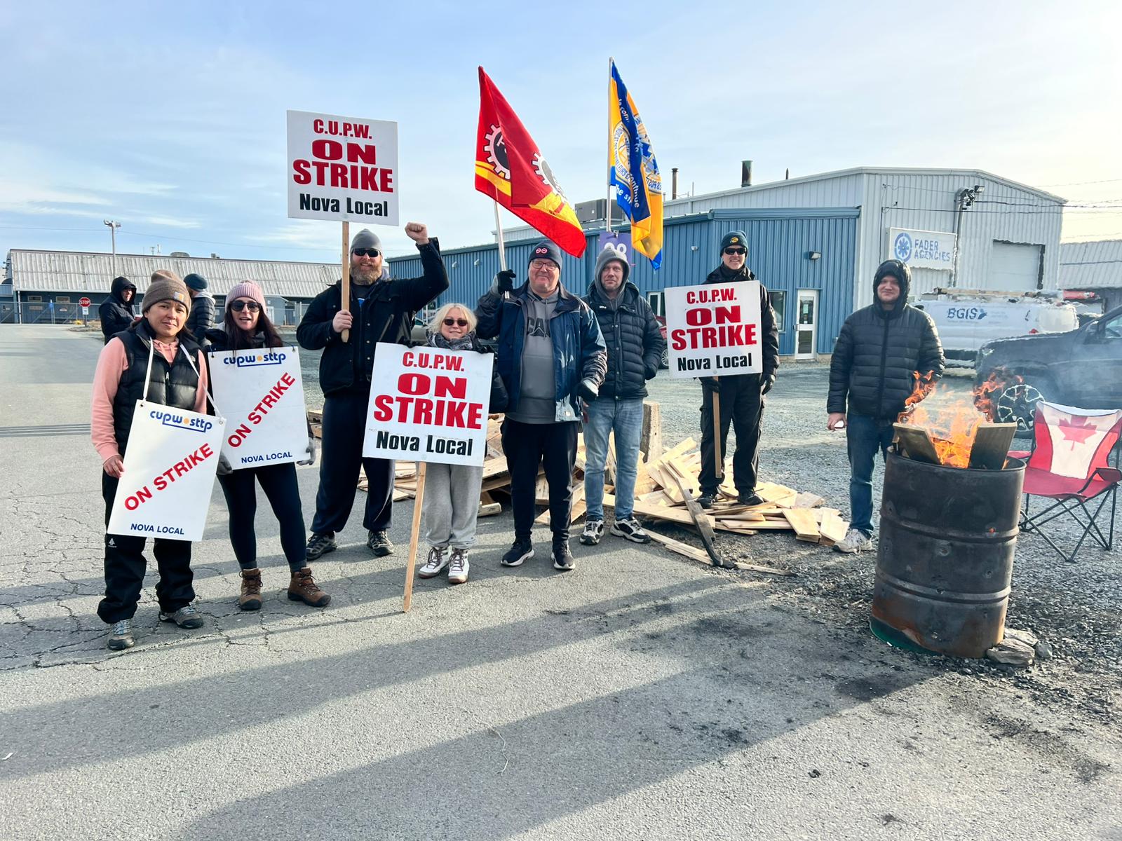 Members standing with strike signs and flags